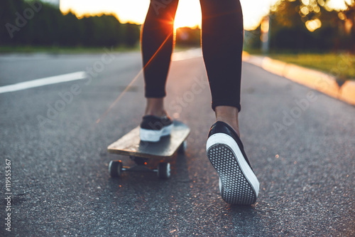 Cuadros en Lienzo Joven patinador piernas montando en patineta en frente del sol