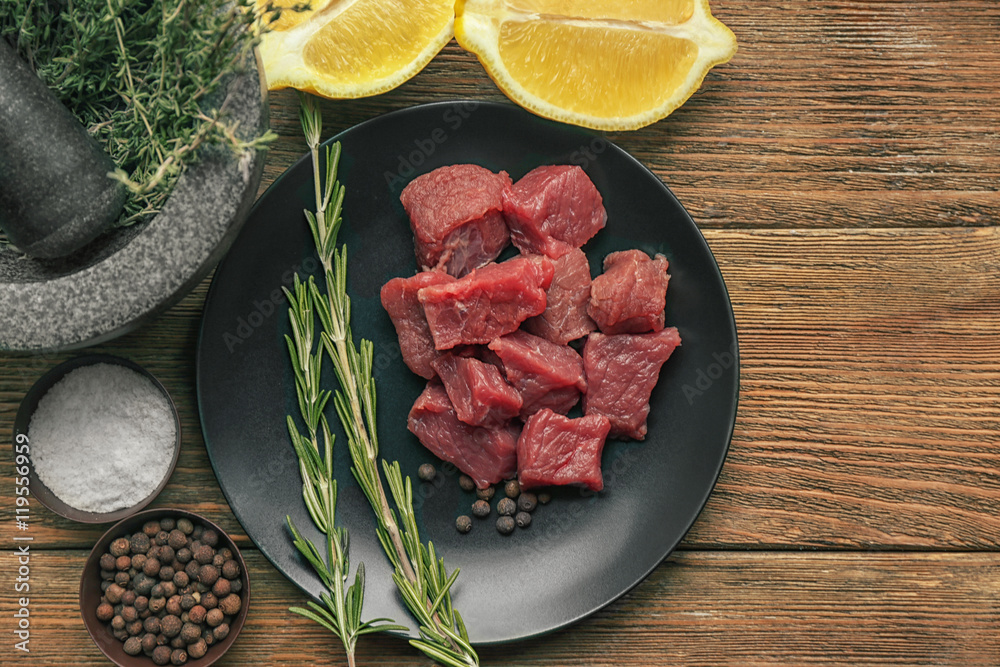 Raw meat with spices and vegetables on table