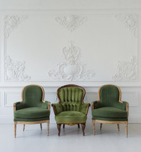 Set Of Green Wooden Vintage Chairs Standing In Front A White Wall Design Bas-relief Stucco Mouldings Roccoco Elements On Light Parquet Floor.