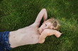 © Cavan Images - Portrait of boy lying on grass at backyard