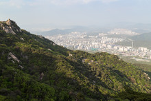 View Of The City Far Away From Above, Mountain And Lush Forest At The Bukhansan National Park In Seoul, South Korea.