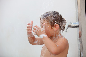 Funny kid showering in the yard