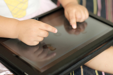 Child hand using touchscreen tablet PC closeup