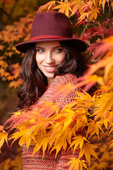 Sticker - Fashion woman on a background of red and yellow autumn leaves