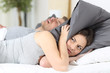 Man snoring and his wife covering ears