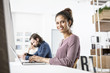 © Westend61 - Smiling woman in office working on laptop