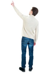 Wall Mural - Back view of pointing business man. Curly short-haired man in a woolen white jacket showing thumb up.