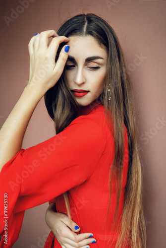 Plakát Elegant beautiful young girl with red long dress, long blonde hair, red lipstick