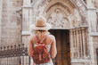 tourist travels in Europe, sightseeing tour, back of woman with backpack looking at historical architecture