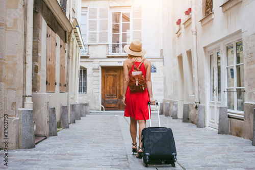 Fotografía travel background, woman tourist walking with suitcase on the street in european