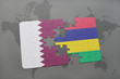 puzzle with the national flag of qatar and mauritius on a world map background.