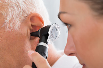 female doctor examining patient's ear