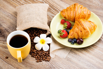 Wall Mural - Cup of coffee and croissants on wooden background