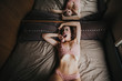 © ADDICTIVE STOCK - Young sexy woman in pink underwear lying on bed and yawns