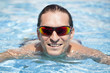© Ricardo Ferrando - Hombre con gafas de sol sonriendo en la piscina
