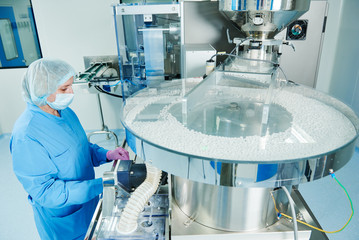 pharmaceutics. pharmaceutical worker operates tablet blister packaging machine