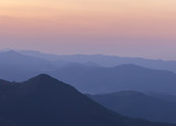 Fototapeta Natura - Silhouettes of the mountain hills after sunset. mountain cascade