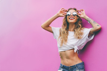 Fun and colorful. Young pretty happy woman in shorts posing agai