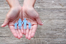 Paper Family In Hands On Wooden Background Welfare Concept