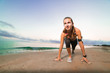 © bodiaphoto - Cute fit girl starts running on beach at sunrise