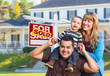 © Andy Dean - Young Family in Front of Sold Real Estate Sign and House