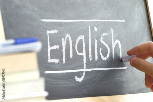 Fotografie, Obraz Hand writing on a blackboard in a language class with the word "English" wrote on