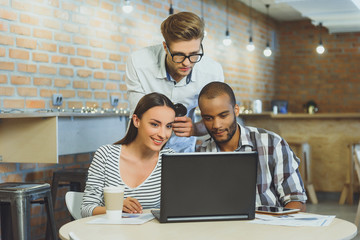 Wall Mural - Creative team using laptop in cafeteria