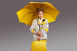 © ZoomTeam - Glamour woman with yellow umbrella and suitcase. Travel concept