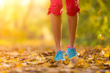 Wall Mural - Close up of feet of a runner running in leaves