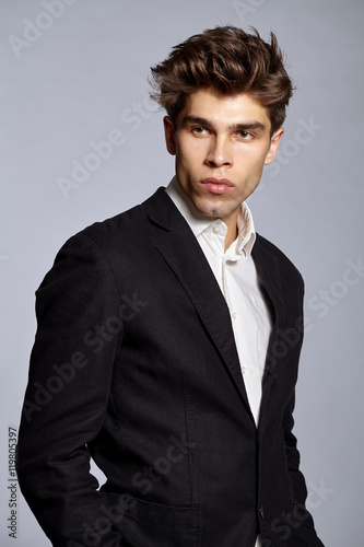 Fototapeta na wymiar Close-up portrait of guy with hairstyle in suit