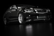 © Photocreo Bednarek - Modern black metallic sedan car in spotlight. Generic desing, brandless.