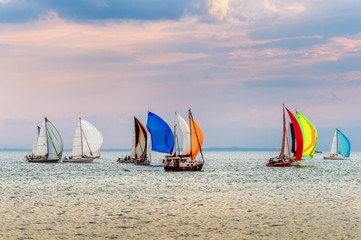 Colorful yachts at sailing competition on Lake Geneva at sunset on a beautiful summer day