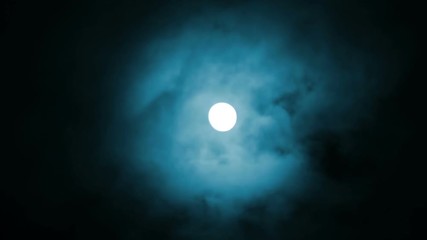 Wall Mural - night view at the moon through blue moving clouds