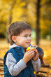 © Olga Gorchichko - Young boy eating sweet cupcake in autumn park