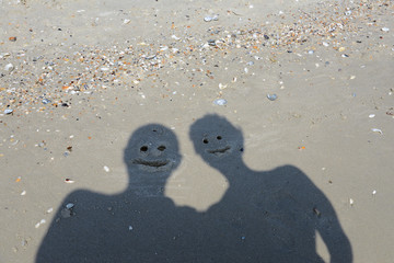 two smiling shadow on the beach