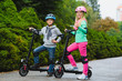 Happy kids standing on electric scooter outdoor