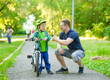 © Ermolaev Alexandr - father talking with his son riding a bicycle