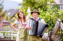 Couple In Traditional Bavarian Clothes With Accordion, Green Gar