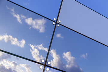 Wall Mural - blue sky and clouds reflect in glass panes of modern building