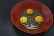 сырые куриные яйца на красной тарелке