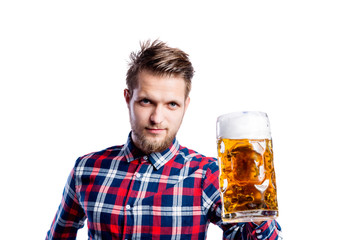 Wall Mural - Hipster man in checked shirt holding beer, studio shot