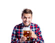 Hipster man in checked shirt drinking beer, studio shot