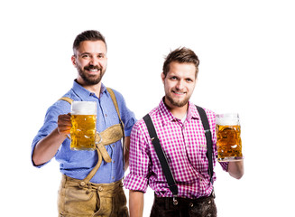 Wall Mural - Men in traditional bavarian clothes holding mugs of beer