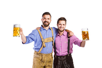 Wall Mural - Men in traditional bavarian clothes holding mugs of beer