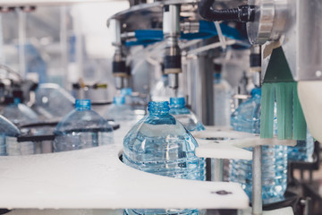 Wall Mural - Water bottling line for processing and bottling pure spring water into bottles. Selective focus.