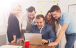 © Prostock-studio - Happy business people team together look at laptop in office