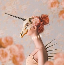 Woman With Long Neck Wearing Unicorn Skull On Head