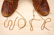 Pair of work shoes with shoelaces on wooden background