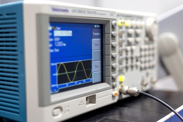 oscilloscope lab item on the table, a photo with a small depth of field, buttons and switches