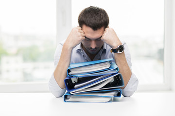 Wall Mural - sad businessman with stack of folders at office